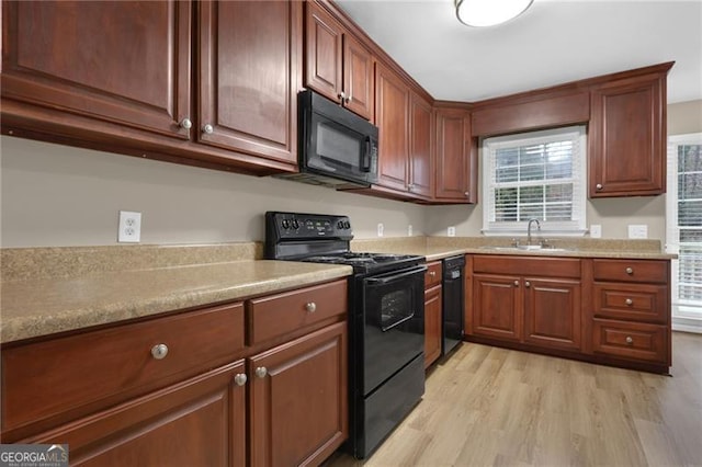 kitchen featuring sink, light hardwood / wood-style flooring, and black appliances