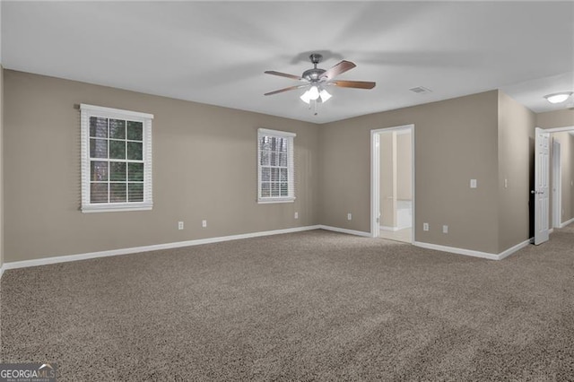 carpeted spare room featuring ceiling fan