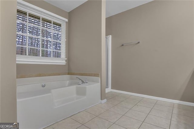 bathroom with tile patterned flooring and a tub to relax in