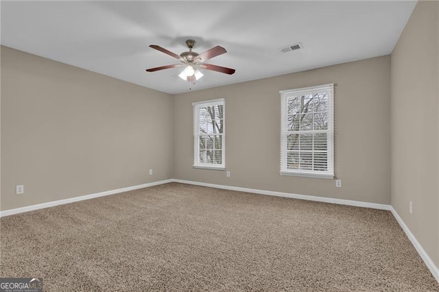 carpeted spare room featuring ceiling fan