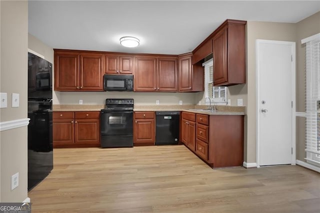 kitchen featuring light hardwood / wood-style floors, sink, and black appliances