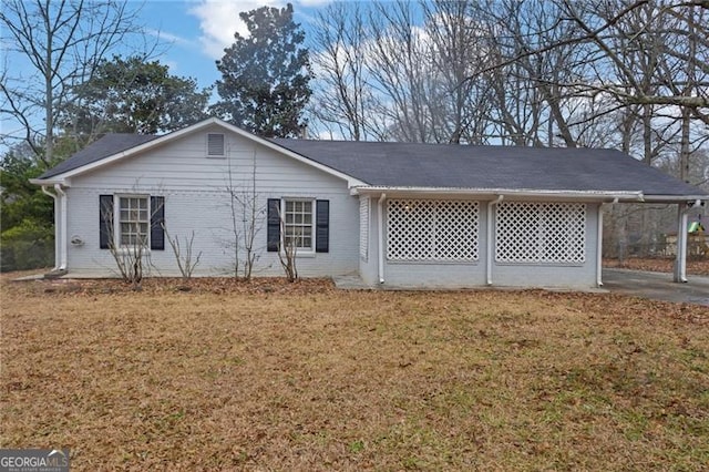 rear view of property featuring a carport and a yard