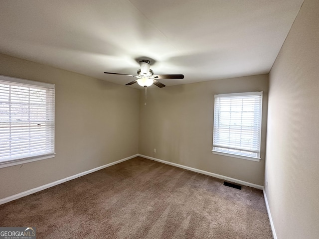 carpeted spare room featuring ceiling fan