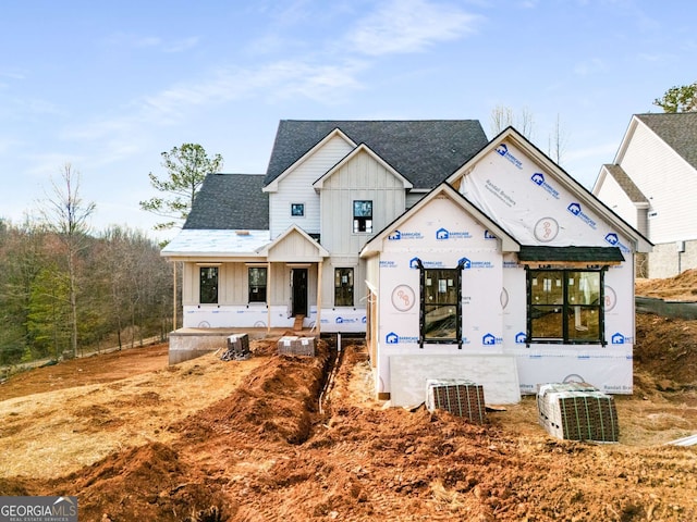 property under construction with board and batten siding and roof with shingles