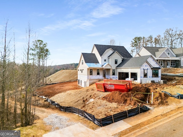 view of front facade featuring board and batten siding, driveway, fence, and an attached garage