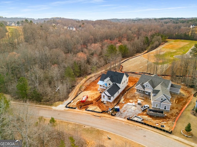 bird's eye view with a wooded view