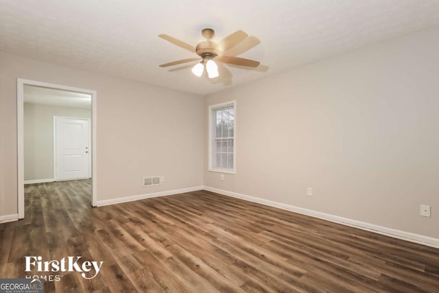 empty room with dark hardwood / wood-style floors and ceiling fan