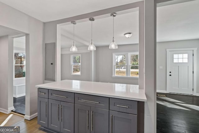 kitchen with dark wood-type flooring, decorative light fixtures, and gray cabinets