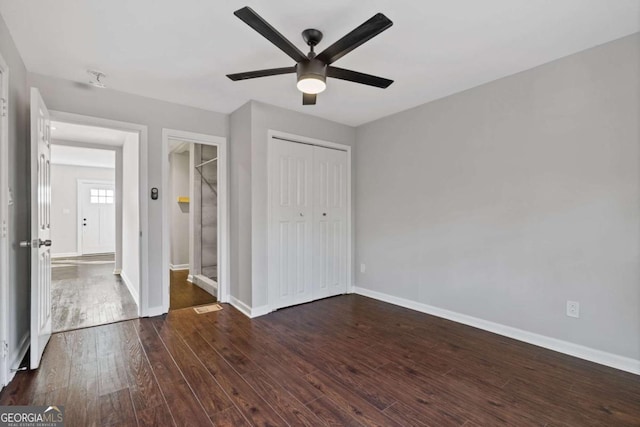 unfurnished bedroom featuring dark hardwood / wood-style flooring, a closet, and ceiling fan