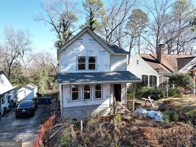 property in mid-construction featuring a shingled roof and driveway