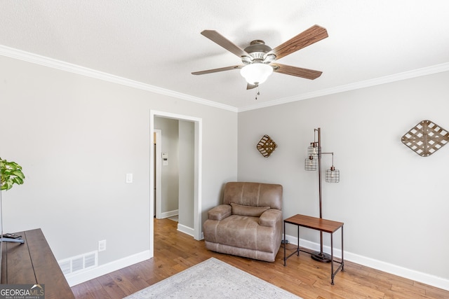 sitting room featuring ornamental molding, ceiling fan, and light wood-type flooring