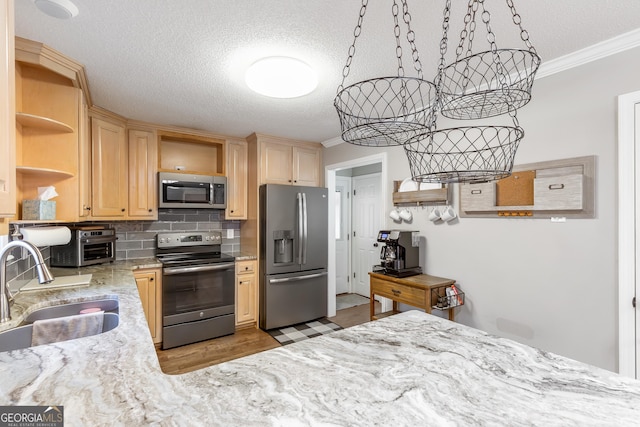 kitchen with stainless steel appliances, ornamental molding, sink, and tasteful backsplash