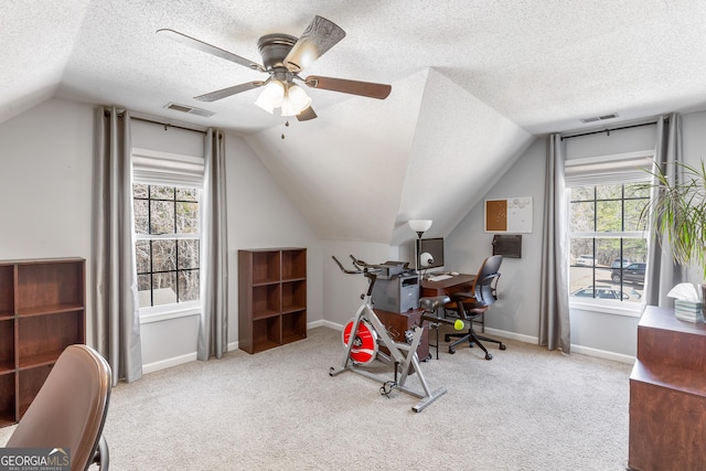 carpeted home office featuring ceiling fan, lofted ceiling, a healthy amount of sunlight, and a textured ceiling