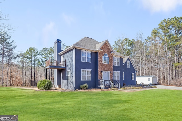 view of front of house featuring a balcony and a front yard