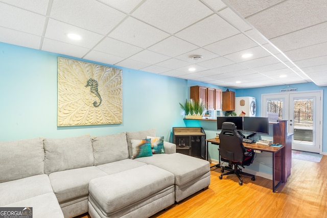 office with a drop ceiling, light hardwood / wood-style flooring, and french doors