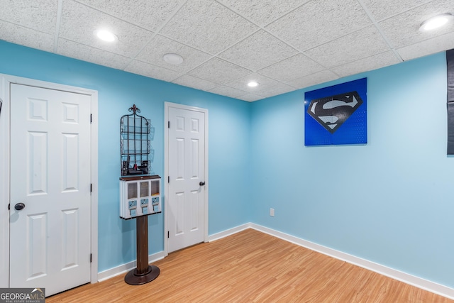 spare room with hardwood / wood-style flooring and a paneled ceiling