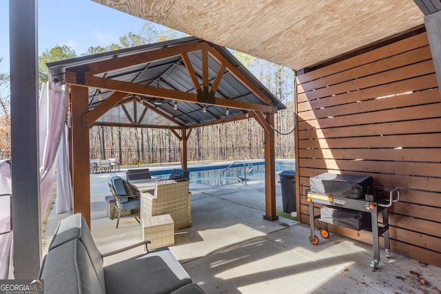 view of patio / terrace with a fenced in pool, a gazebo, and grilling area