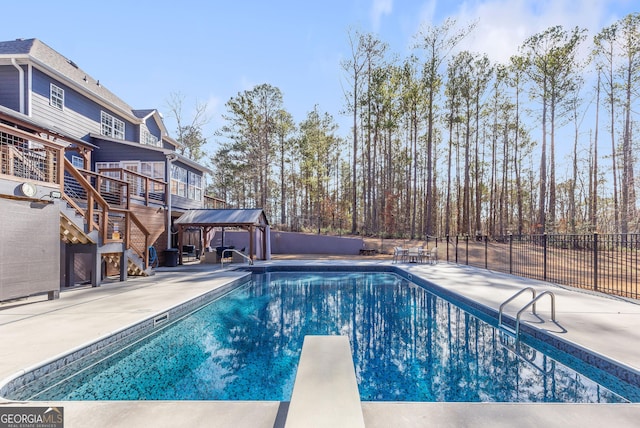 view of pool with a patio area, a diving board, and a deck