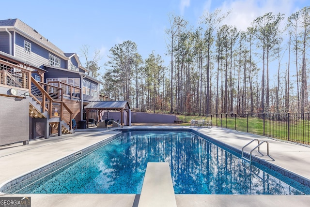 view of swimming pool featuring a diving board, a patio, and a deck