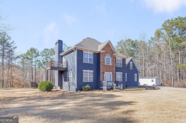 view of front of property featuring a garage, an outdoor structure, and a front lawn