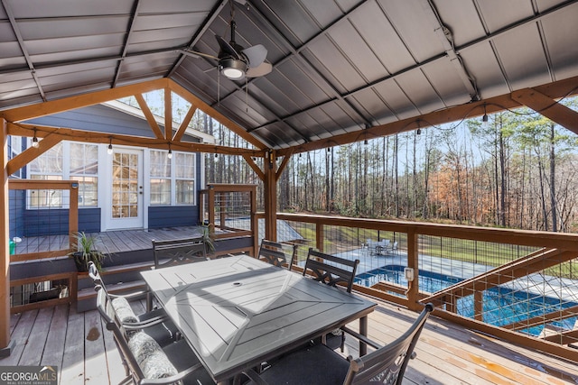 wooden terrace with ceiling fan and a swimming pool