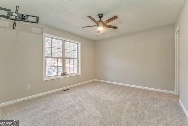 carpeted empty room featuring a textured ceiling and ceiling fan