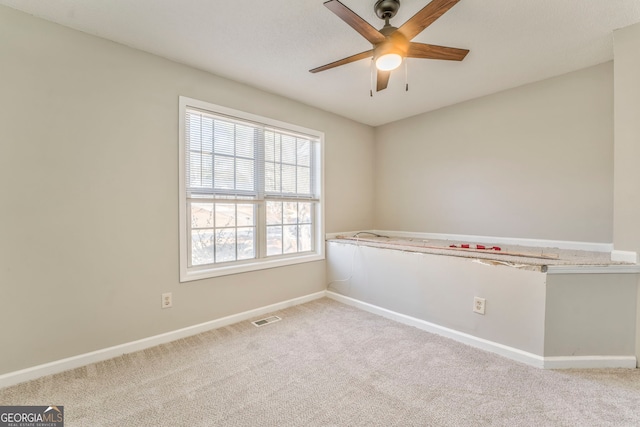 carpeted empty room featuring ceiling fan