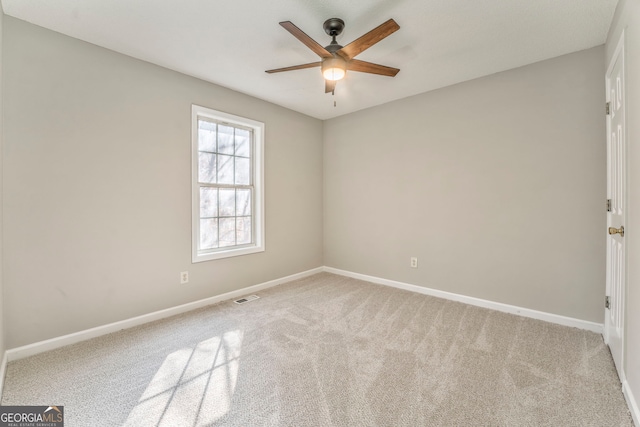 carpeted spare room featuring ceiling fan