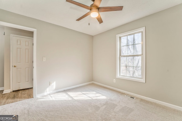 carpeted empty room featuring ceiling fan