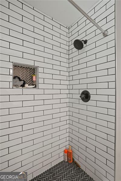 bathroom with tiled shower