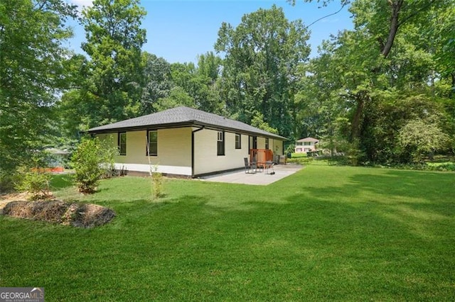 back of house with a patio and a lawn