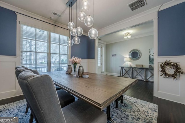 dining area with ornamental molding and dark wood-type flooring