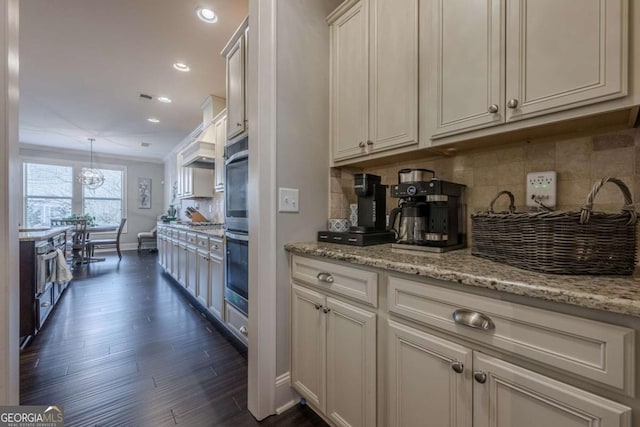 kitchen featuring white cabinetry, decorative light fixtures, light stone counters, and backsplash