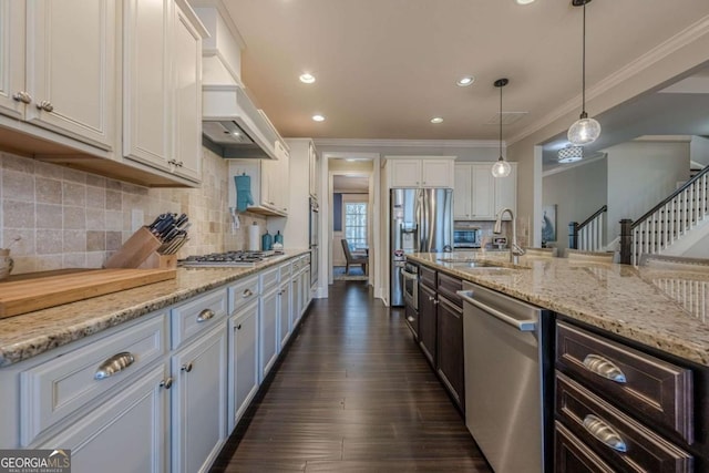 kitchen featuring sink, white cabinetry, hanging light fixtures, stainless steel appliances, and custom exhaust hood