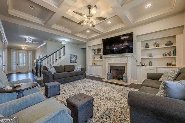 living room featuring crown molding, beam ceiling, dark hardwood / wood-style floors, coffered ceiling, and a fireplace