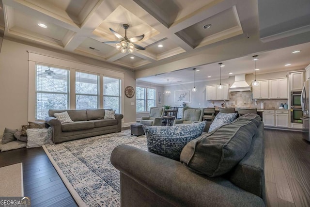 living room featuring beam ceiling, coffered ceiling, dark wood-type flooring, and ceiling fan