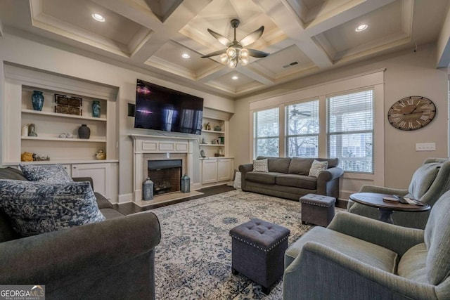 living room featuring beamed ceiling, ceiling fan, coffered ceiling, and a high end fireplace