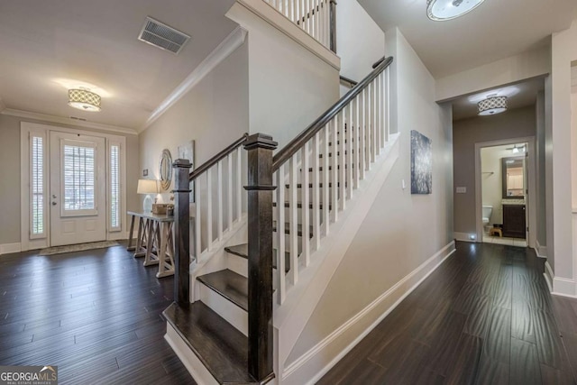 entrance foyer with ornamental molding and dark hardwood / wood-style floors