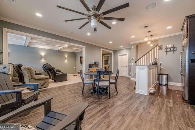 dining space with ornamental molding, hardwood / wood-style floors, and ceiling fan