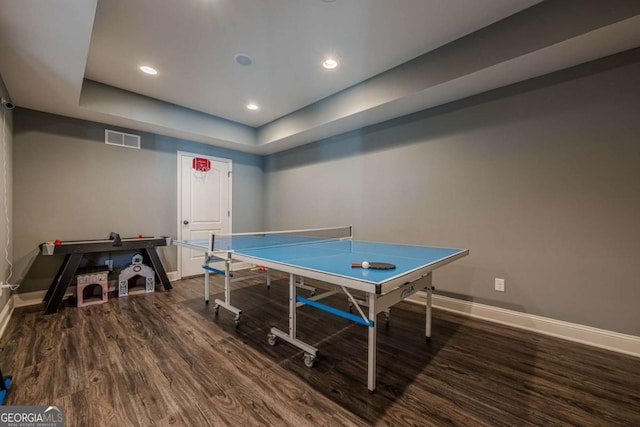 recreation room with a raised ceiling and dark hardwood / wood-style flooring