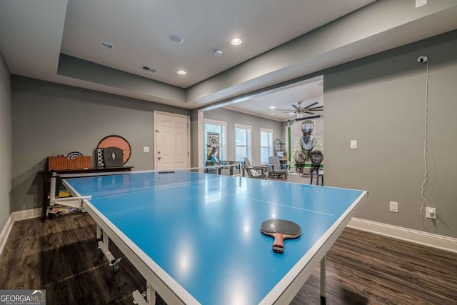 playroom featuring a raised ceiling, dark wood-type flooring, and ceiling fan