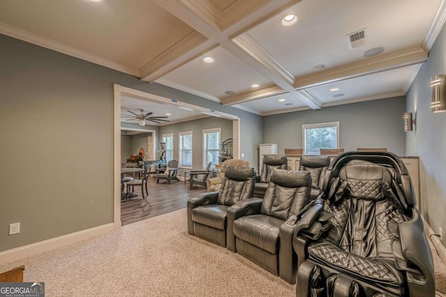 carpeted cinema room with coffered ceiling, plenty of natural light, beam ceiling, and crown molding