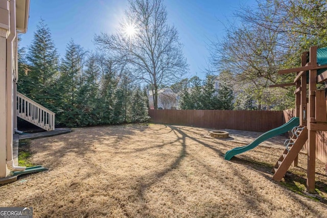 view of yard with a playground and a fire pit