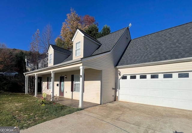 cape cod-style house with a porch, a garage, and a front lawn