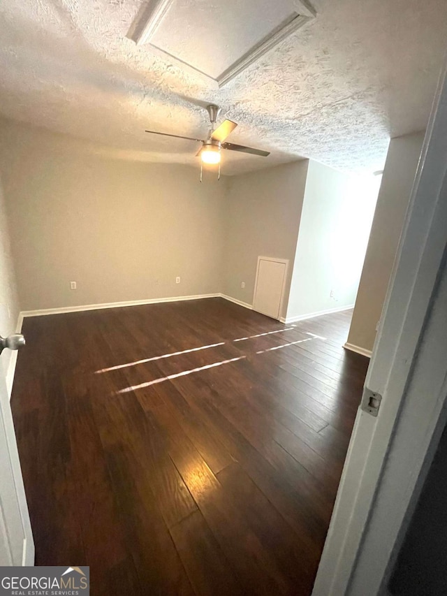 unfurnished room featuring ceiling fan, a textured ceiling, and dark hardwood / wood-style flooring