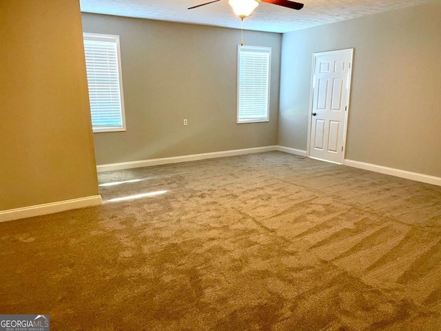 spare room with a textured ceiling, ceiling fan, and carpet