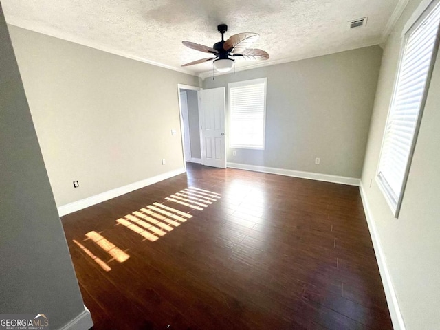 unfurnished room with dark hardwood / wood-style flooring, a wealth of natural light, ornamental molding, and ceiling fan