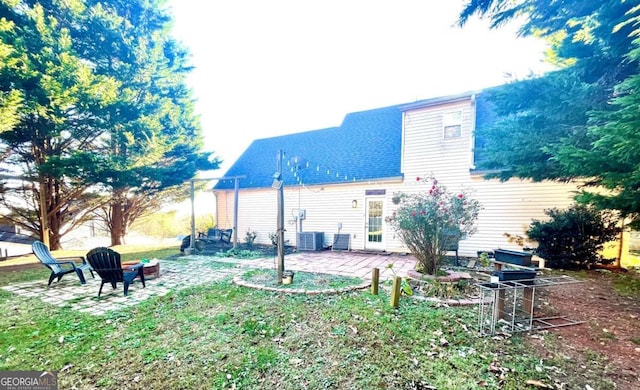 rear view of house with an outdoor fire pit, cooling unit, and a patio area