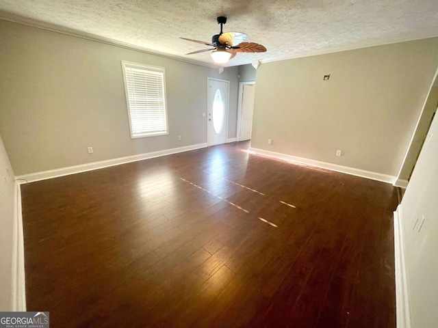 spare room featuring ceiling fan, dark hardwood / wood-style floors, and a textured ceiling