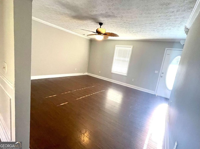 spare room with ornamental molding, dark wood-type flooring, a textured ceiling, and ceiling fan